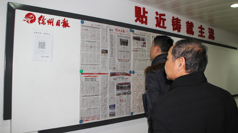 采风团成员认真观看徐州日报宣传资料